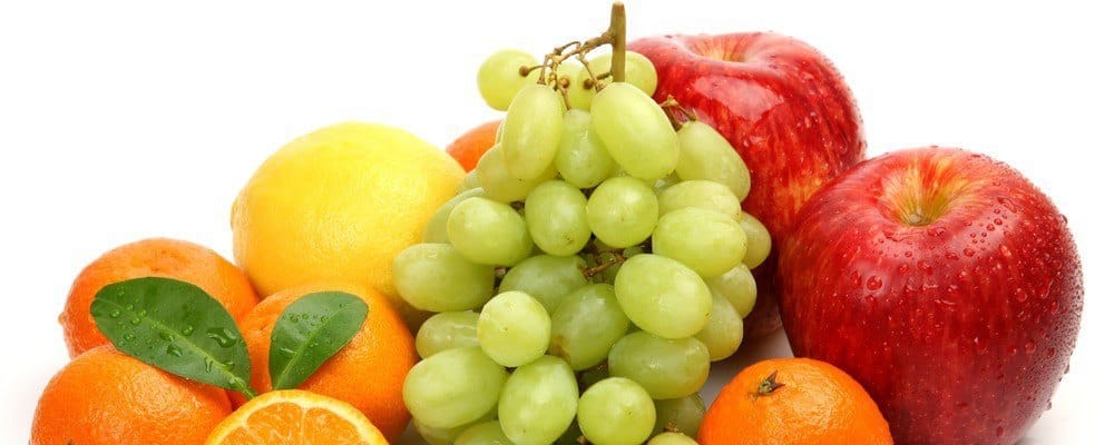 A bunch of fruit (grapes, oranges, apples, a lemon).