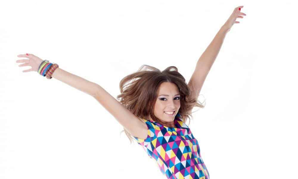 A young woman throwing her arms in the air in joy.