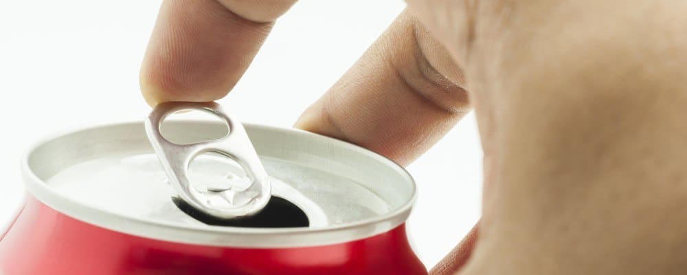 Close-up of a person's hand opening a can of soda.
