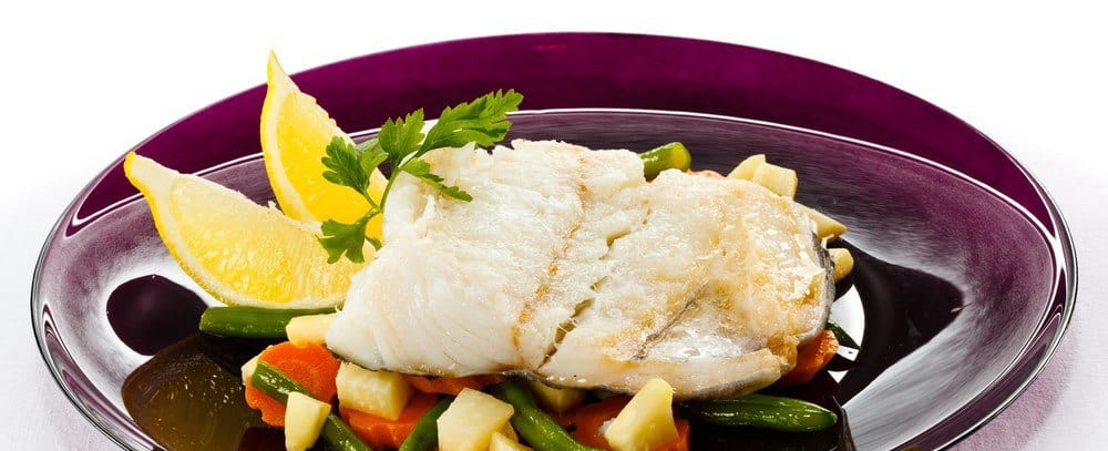 A plate of fish with vegetables.