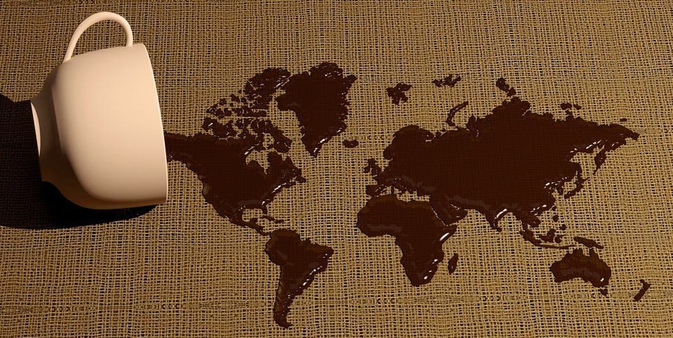 Spilled coffee from a cup forming a world map.