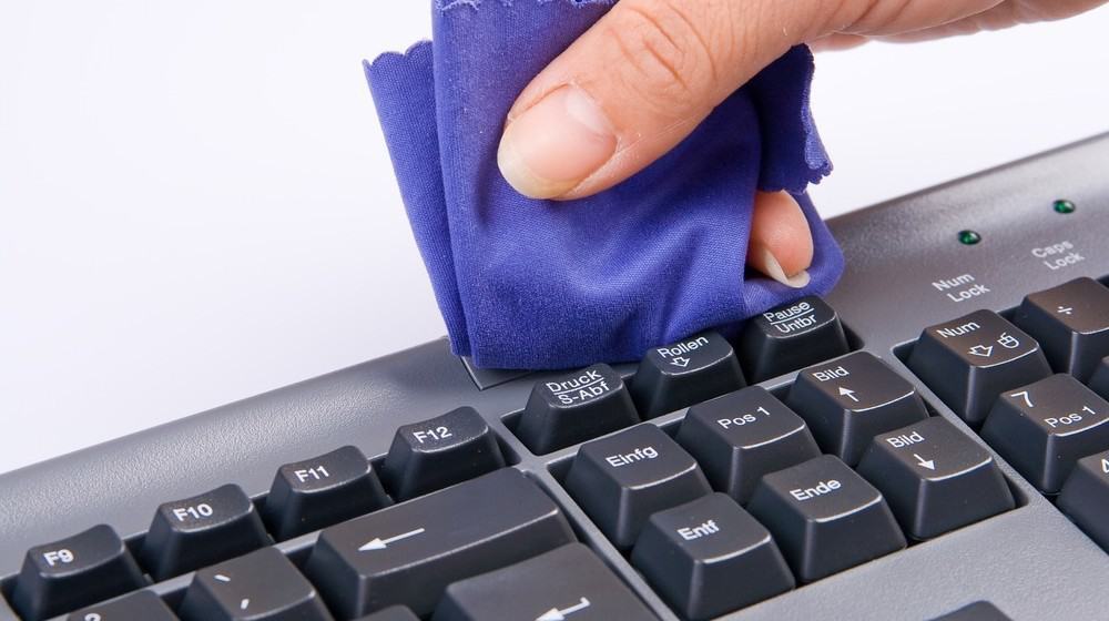 A keyboard being cleaned with a cloth.