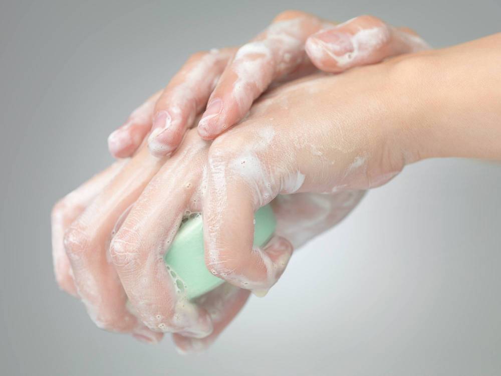 A woman using soap on her hands.