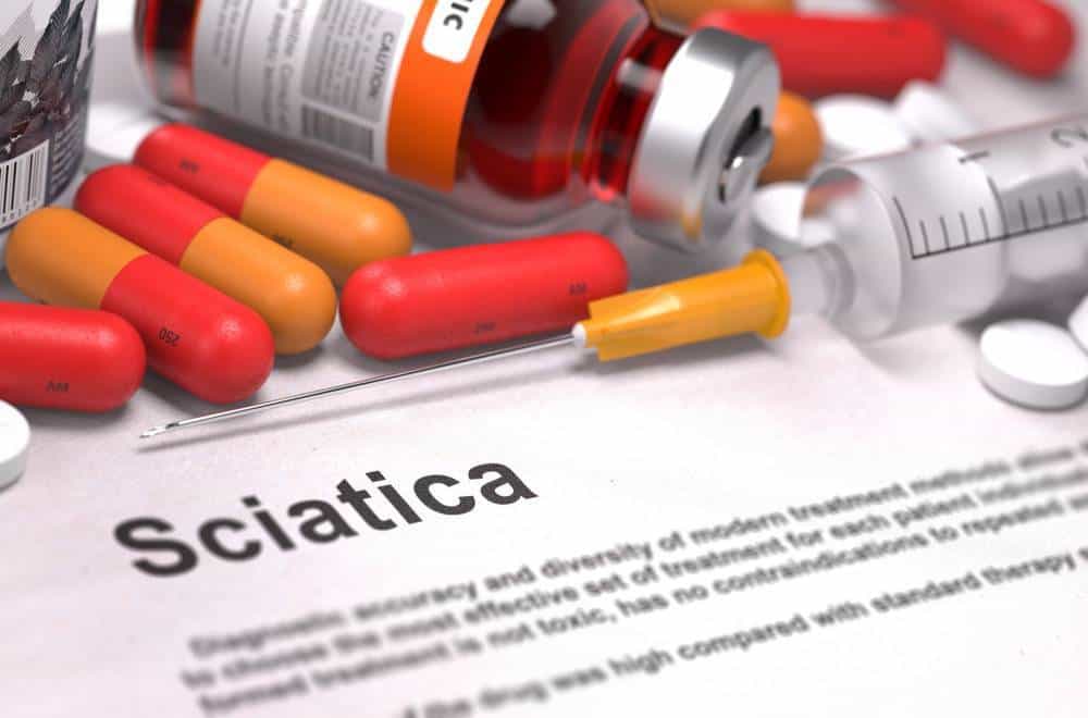 Capsules, a syringe and a paper with Sciatica written on it.