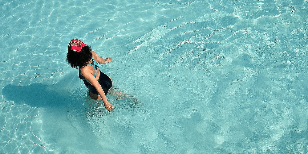 A woman walking in a pool.