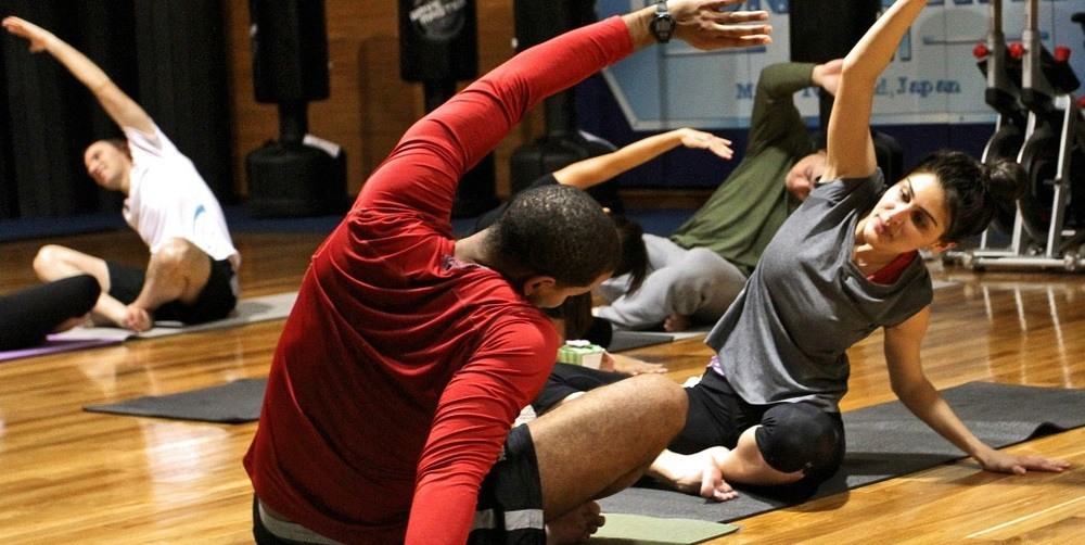 A group of people stretching during a gym exercise.