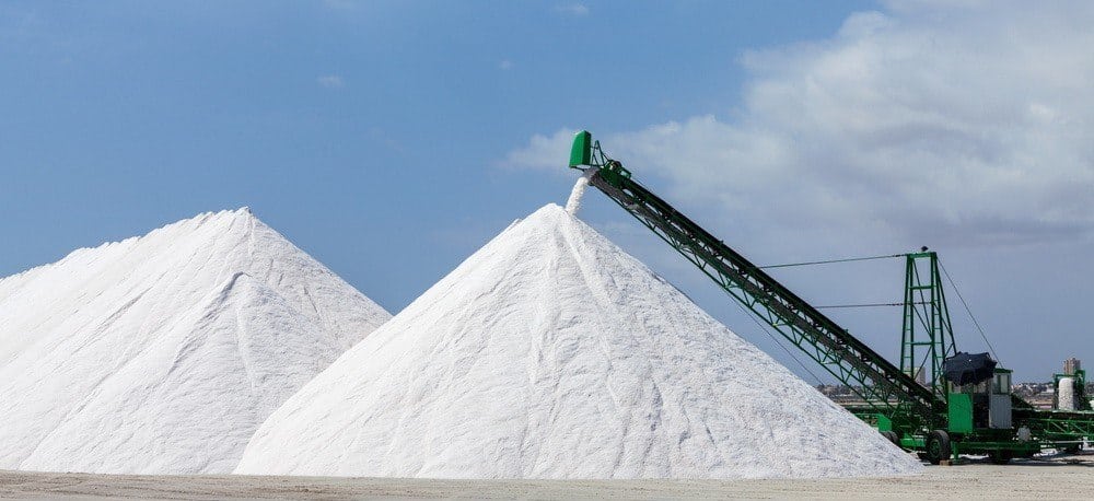 Two huge salt mounds at a factory.