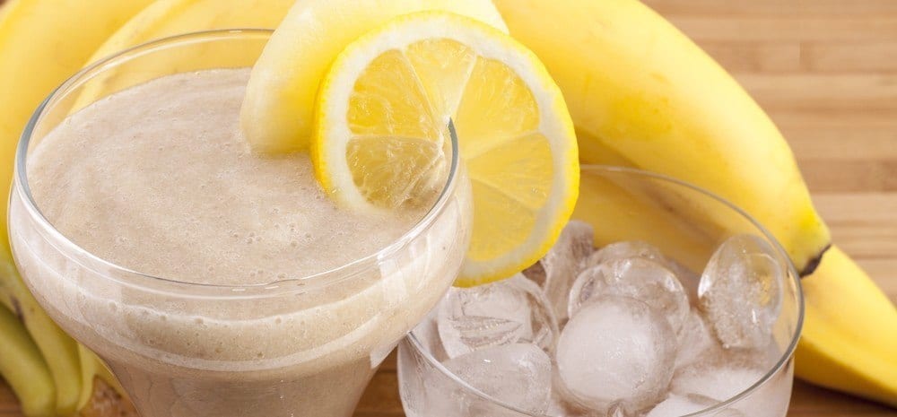 A banana shake with bananas, ice and a slice of lemon.