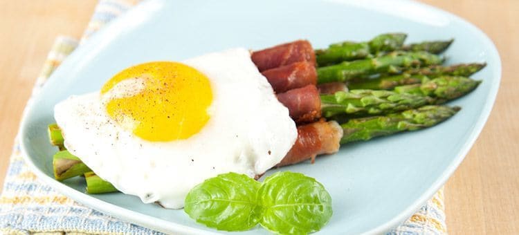 A plate of egg, bacon and vegetable breakfast.