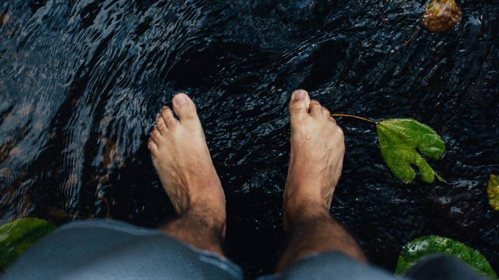 A man's feet in water.