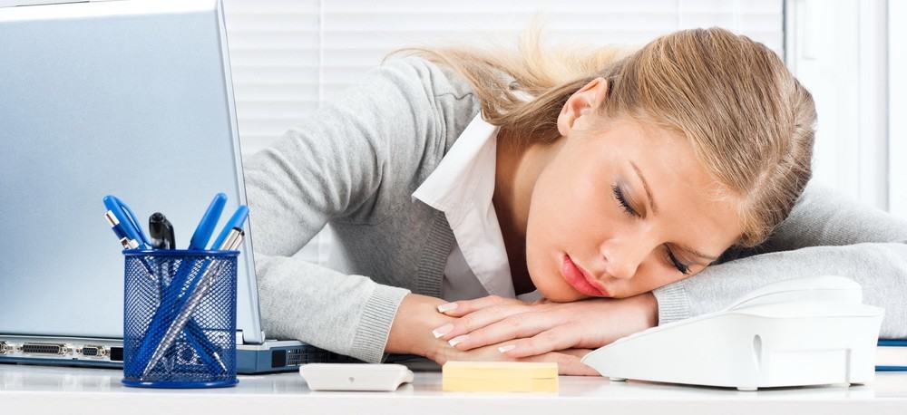 A businesswoman taking a nap at her desk.
