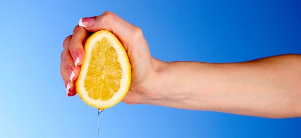 Hand of a woman squeezing a lemon.