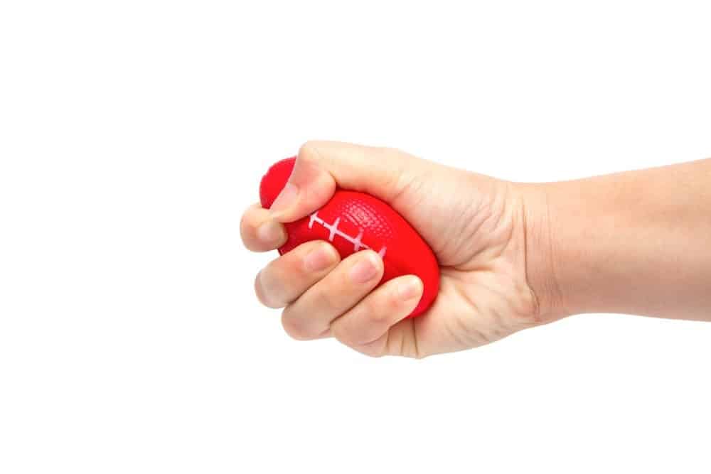 A hand squeezing a squeeze ball.