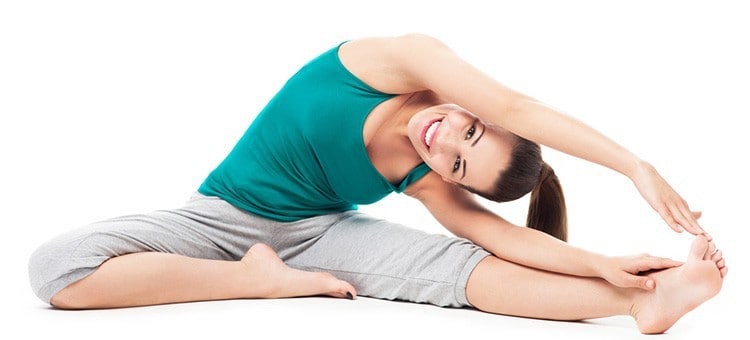 A woman smiling during a stretching exercise.