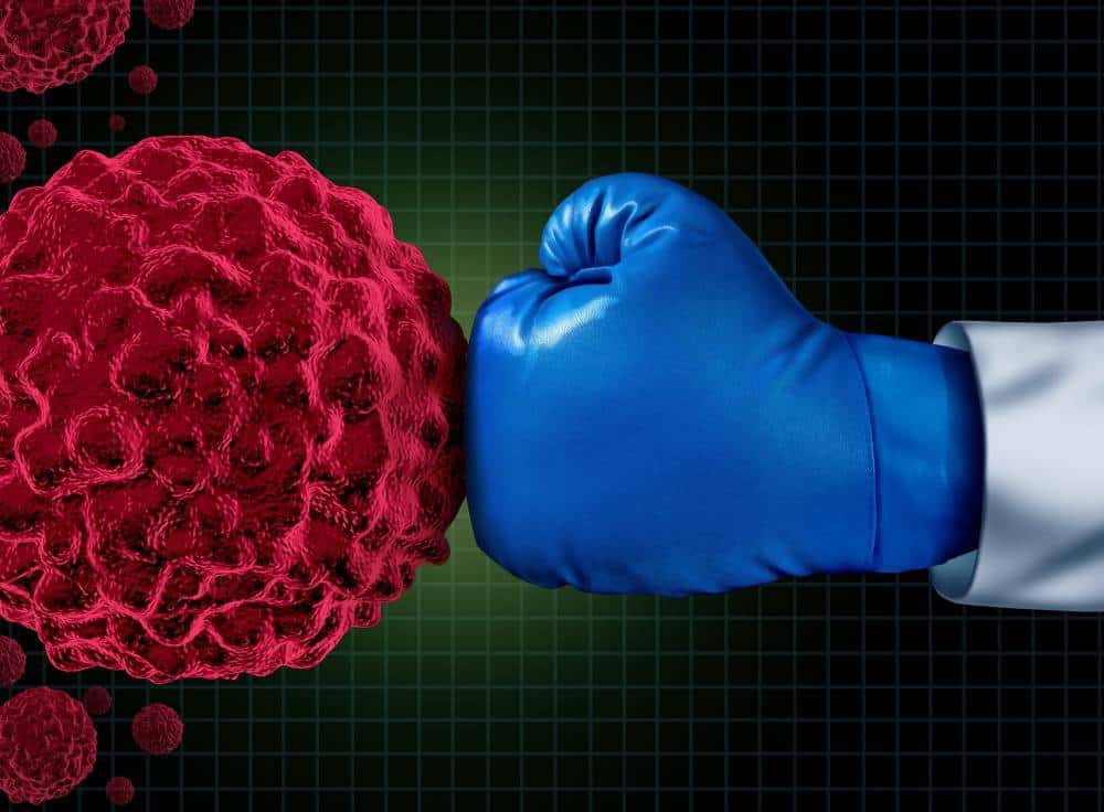 A boxing glove hitting cancer cells.