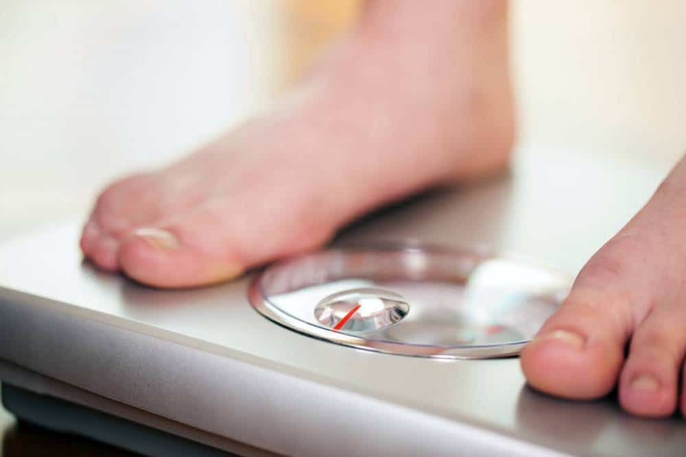 A person checking their weight using a bathroom scale.