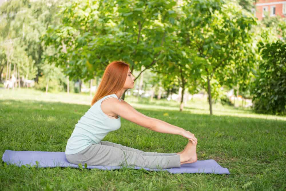 A woman stretching in a park.