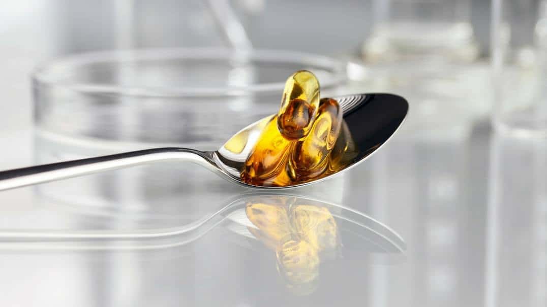 Fish oil capsules in a spoon.
