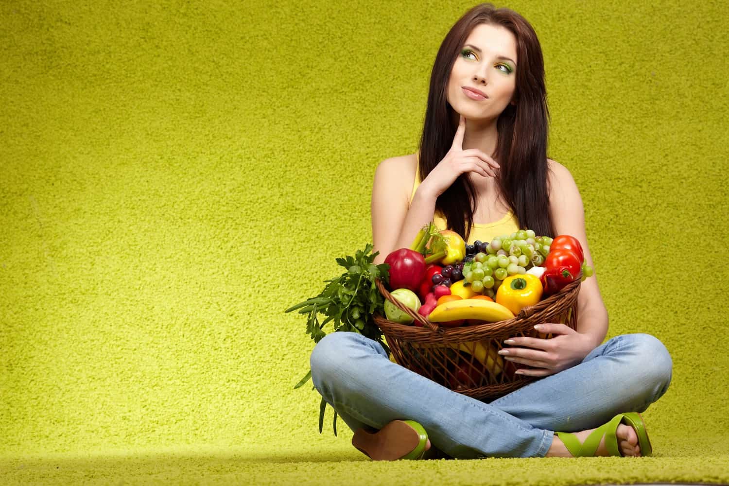 A woman with a basket of fruit and vegetables.