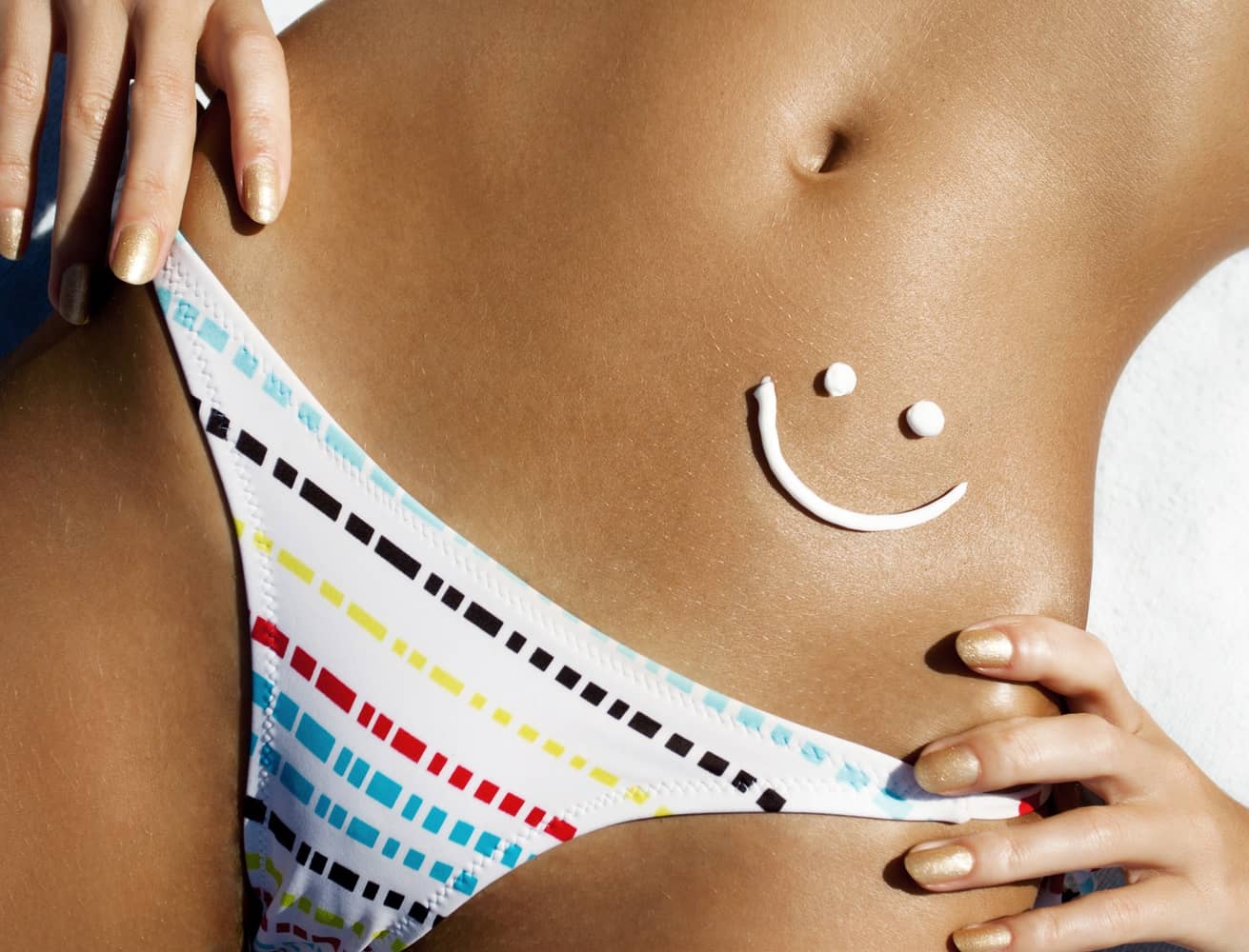 A woman with smiley-shaped lotion on her belly.