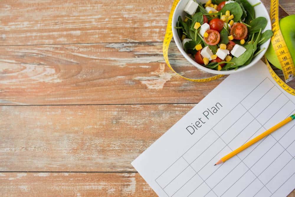 Close up of diet plan and food on table