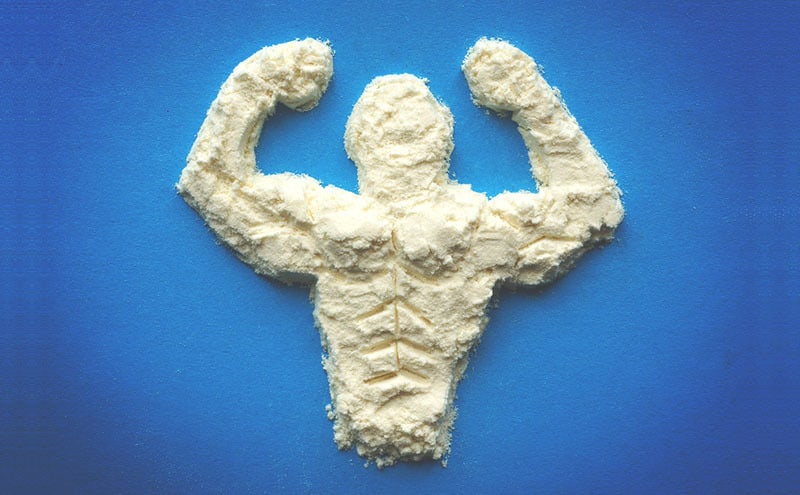 A muscly man flexing on a blue background formed from the best value protein powder.