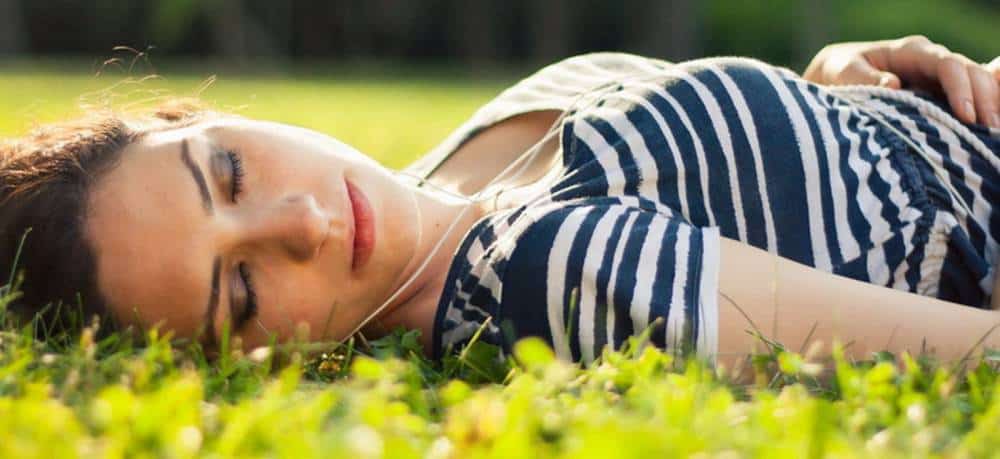 A woman sleeping in a grass.