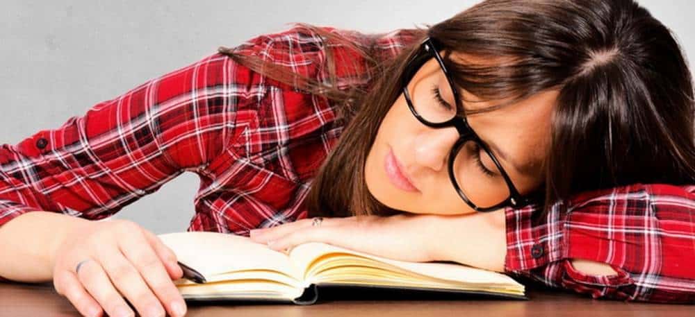 A woman sleeping on a book.